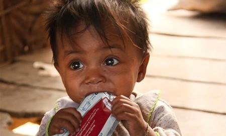 Child consuming eeZeePaste™ NUT